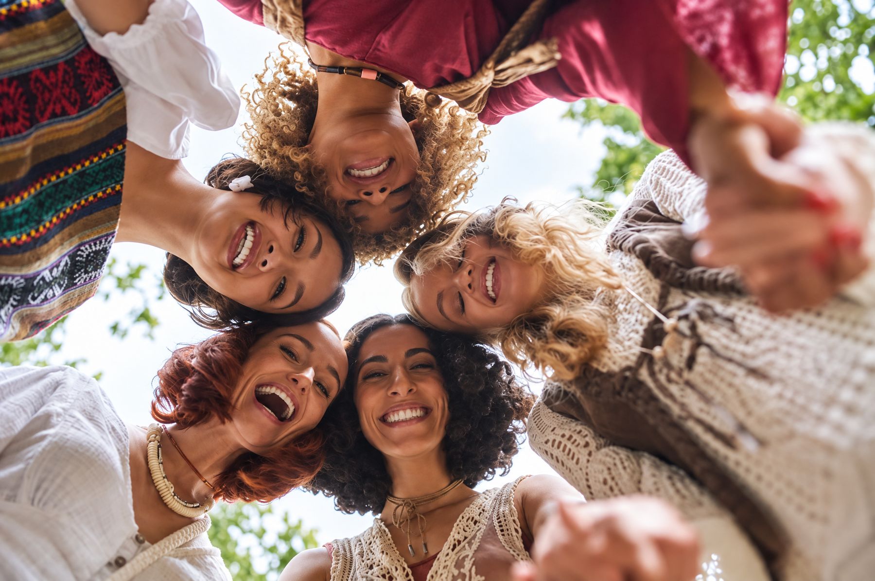 Circle of smiling women looking down into the camera